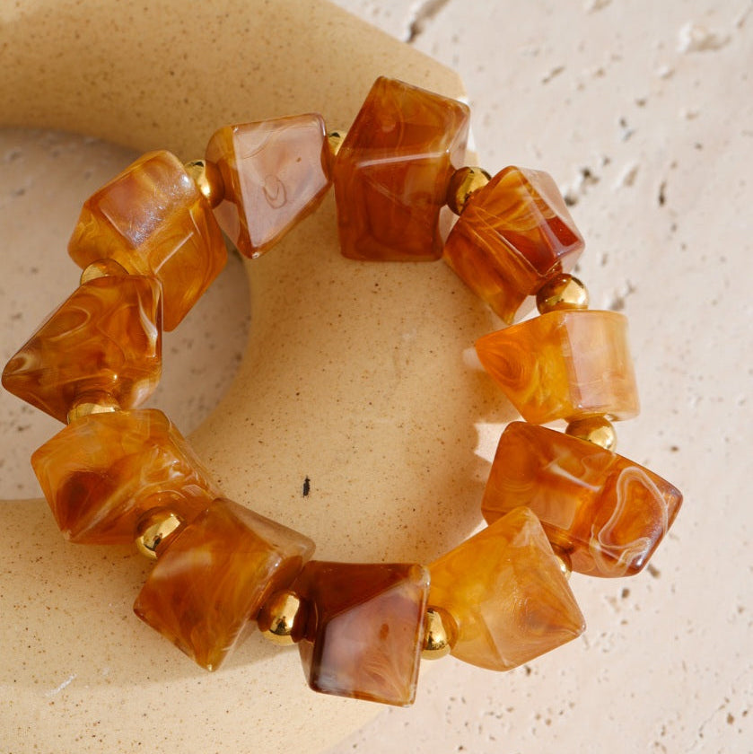 Brown beaded bracelet on a textured beige surface